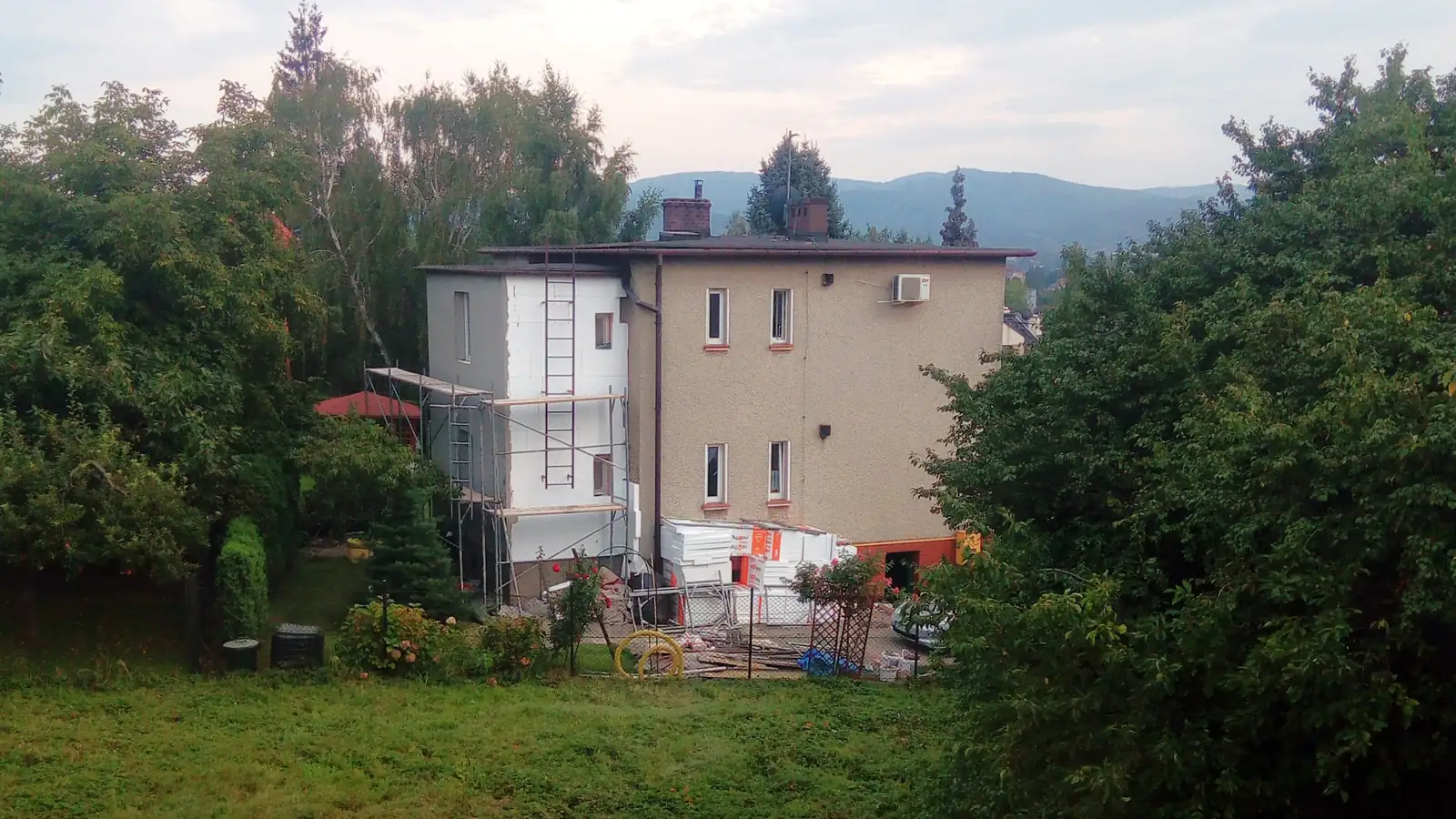 Maison individuelle en cours d’isolation thermique extérieure avec échafaudage et panneaux isolants