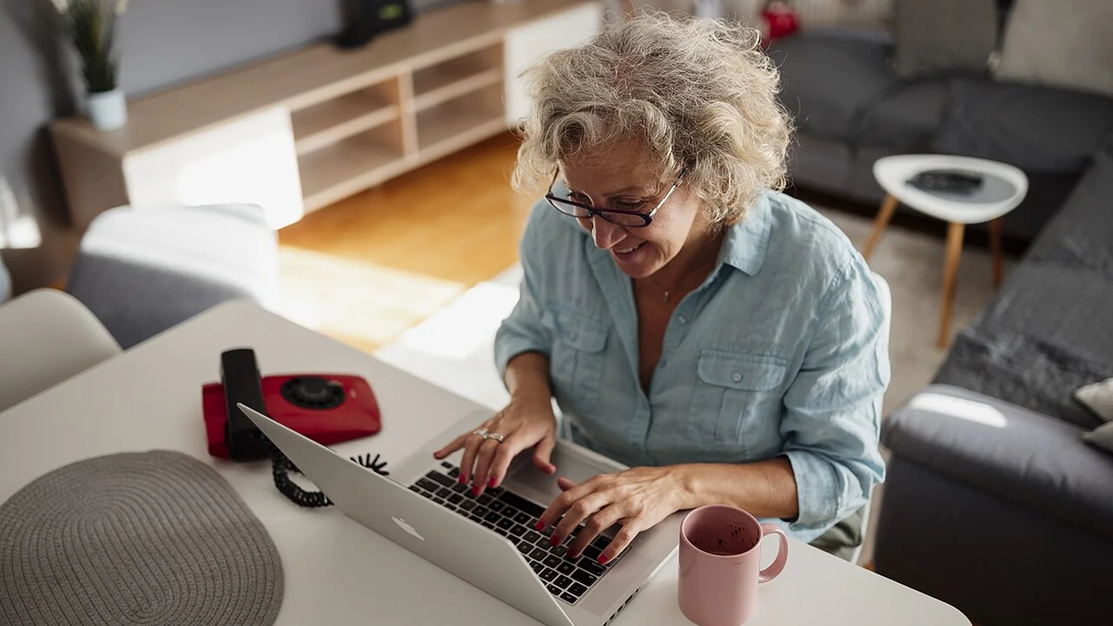 Une femme senior consulte son ordinateur portable à son domicile pour vérifier sa pension de retraite