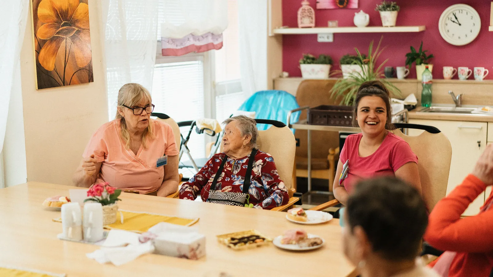Des résidentes et des aidantes réunies autour d'une table dans une maison de retraite