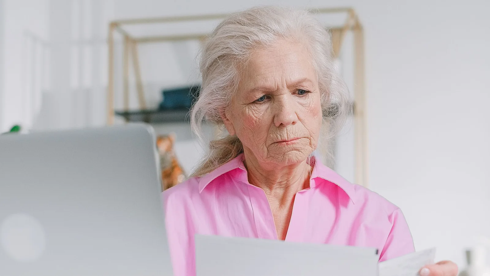 Une retraitée consulte des documents administratifs devant son ordinateur portable
