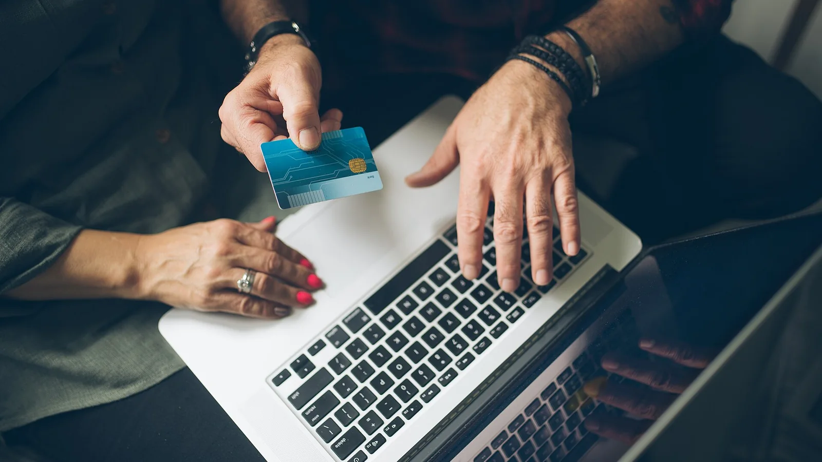 Couple de retraités consultant un compte bancaire en ligne avec une carte bancaire