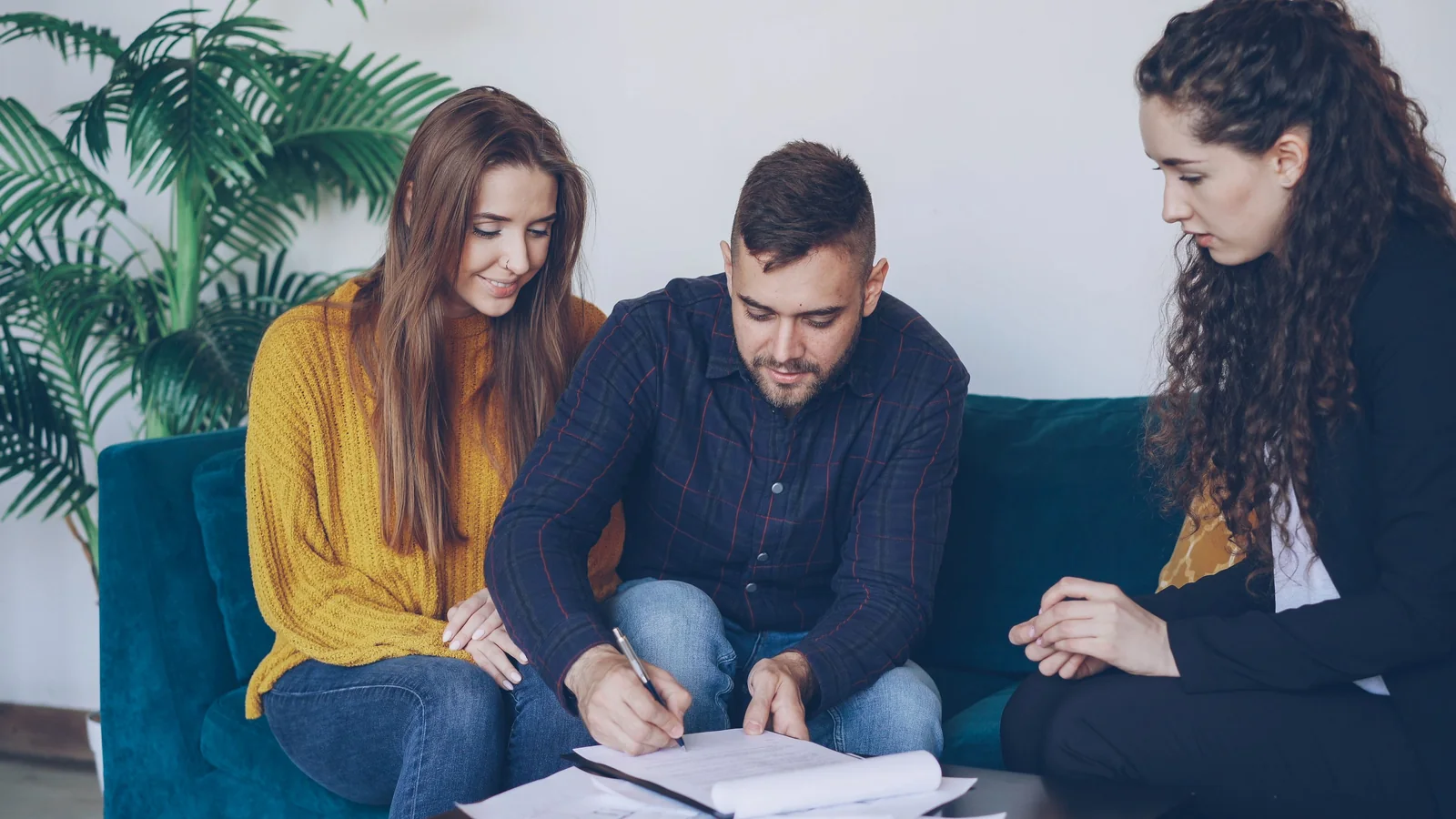 Un couple examine et signe des documents financiers avec une conseillère