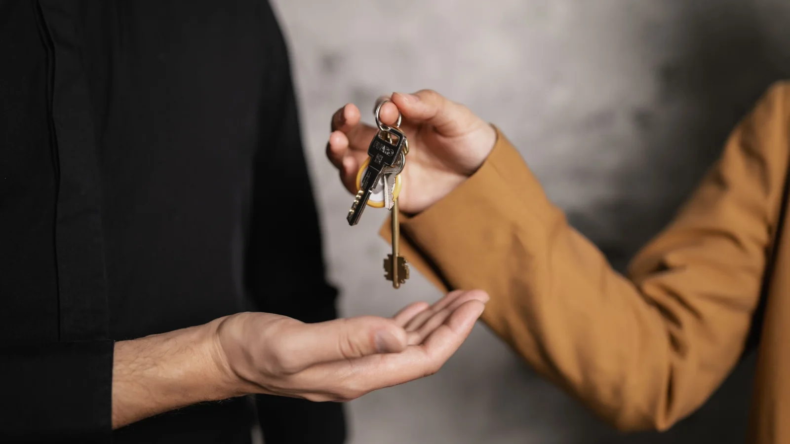 Une personne remet les clés d'un logement à une autre pour symboliser une donation ou une succession immobilière