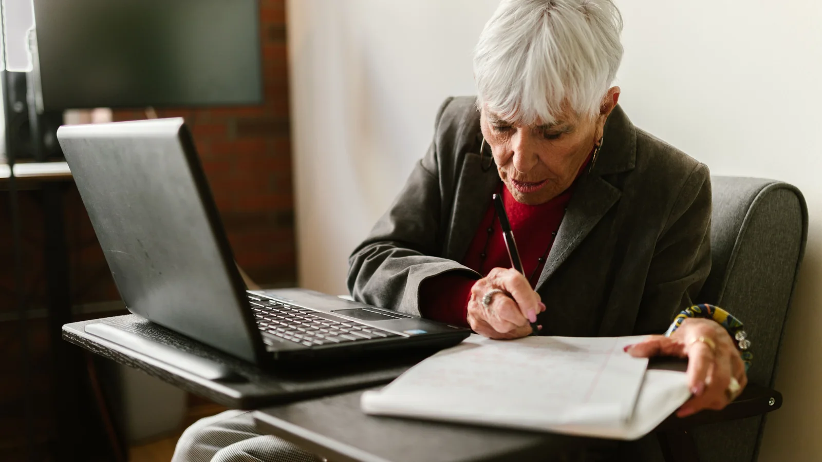 Une femme âgée consulte des informations administratives sur un ordinateur portable