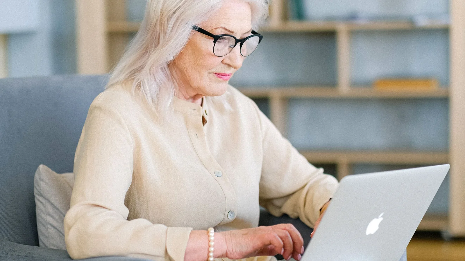 Une femme âgée consulte un ordinateur portable depuis son domicile