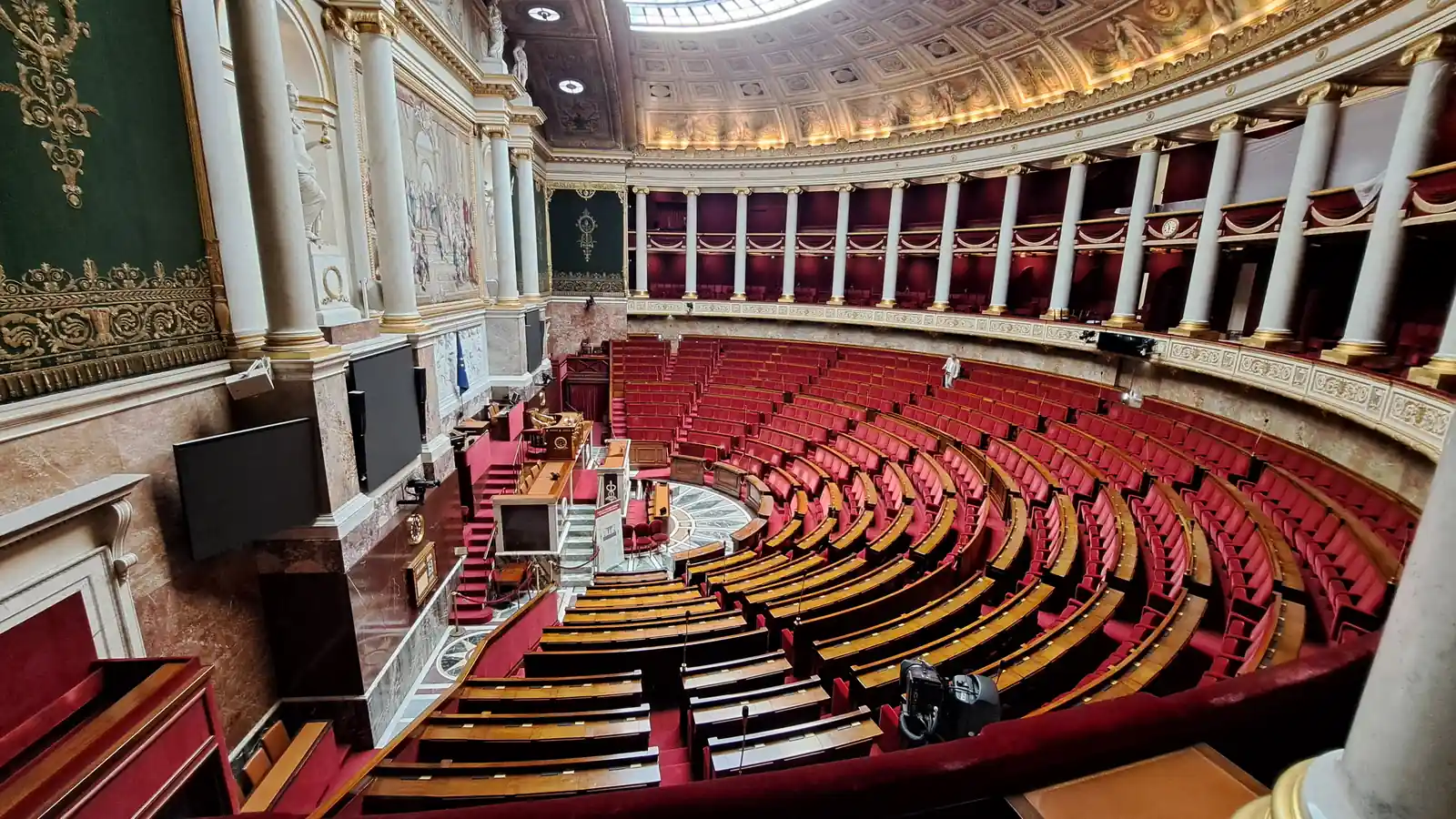 Vue générale de l’hémicycle vide de l’Assemblée nationale, avec ses rangées de sièges rouges