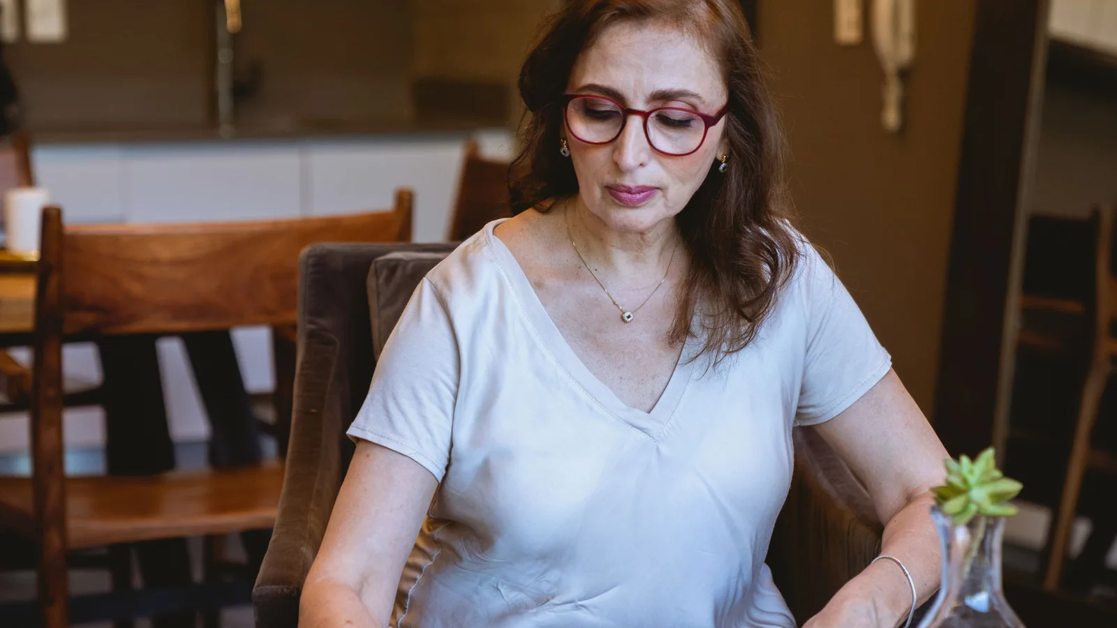 Une femme proche de la retraite calcule son budget devant un carnet et un téléphone