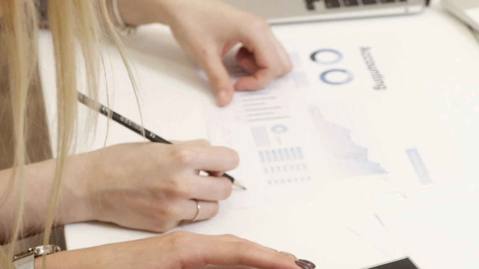 Des professionnelles examinent des documents comptables devant un ordinateur portable