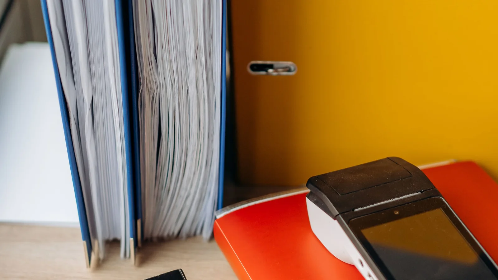 Des dossiers de cotisations rangés à côté de calculatrices sur un bureau