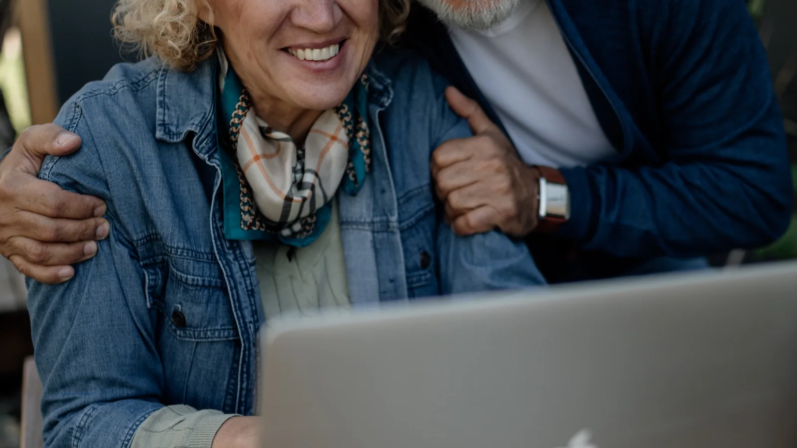 Un couple de seniors consulte ensemble des informations sur un ordinateur portable
