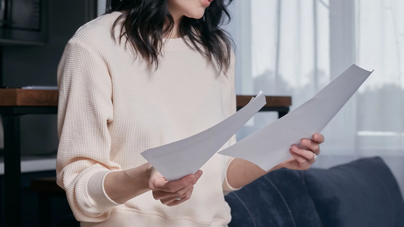 Une femme adulte examine plusieurs documents administratifs à son domicile
