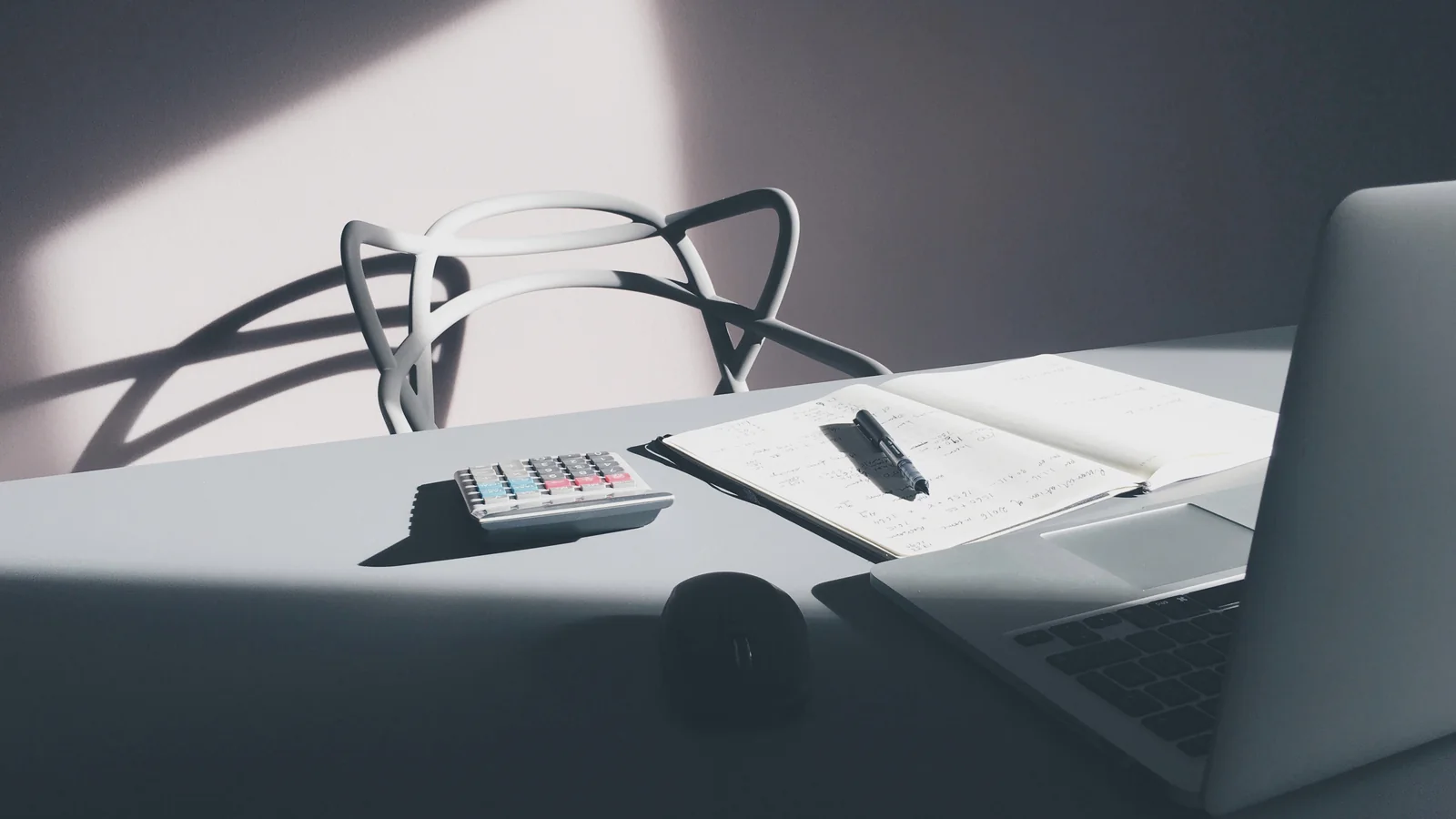 Calculatrice, carnet et stylo sur un bureau pour comparer le quotient familial CAF et fiscal en 2026