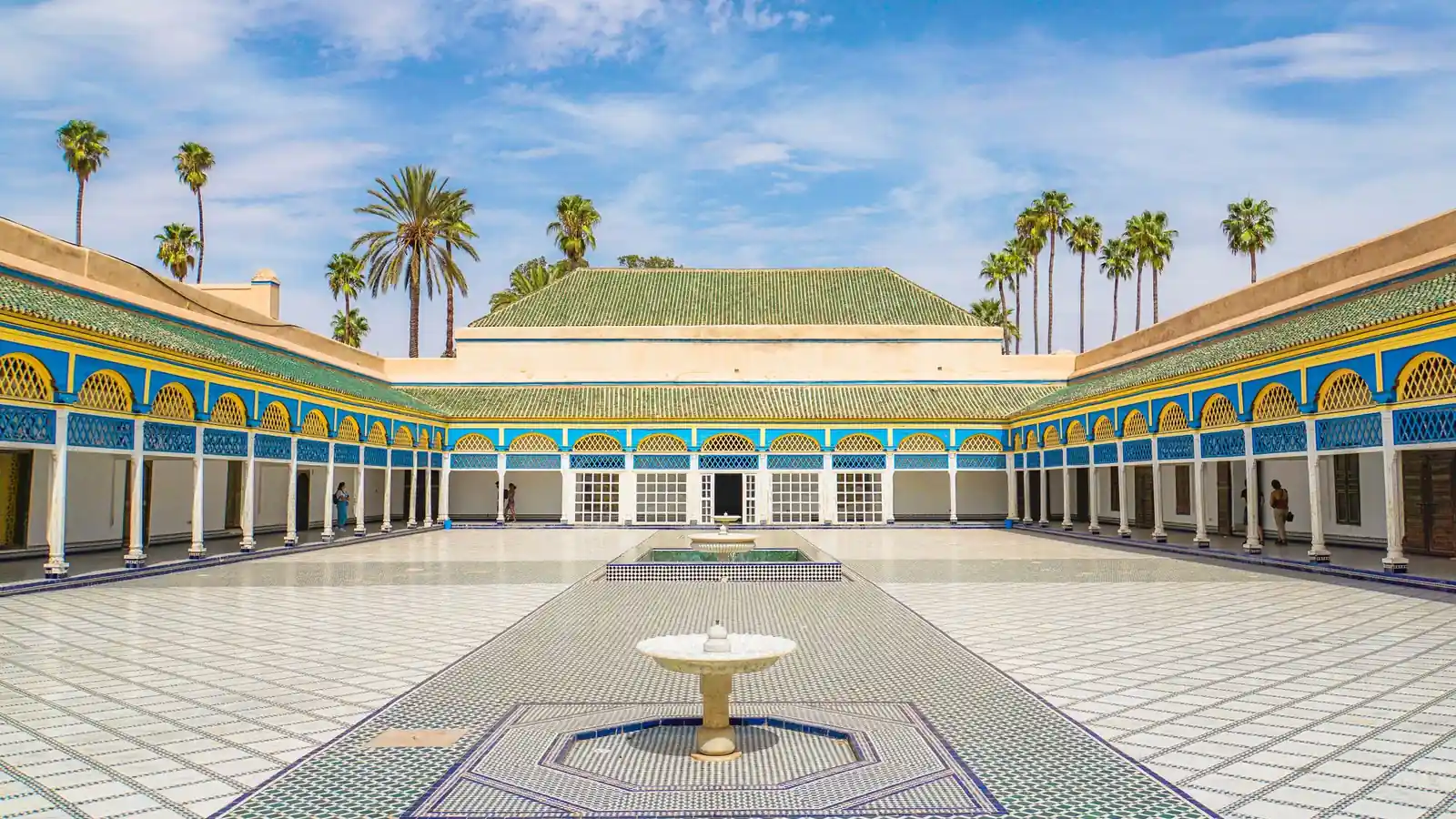 Cour ensoleillée du palais de la Bahia à Marrakech, avec fontaines, mosaïques et palmiers