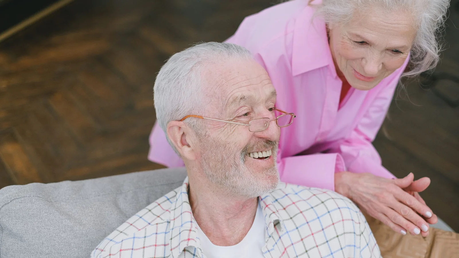 Un couple senior échange dans son salon au sujet de l’organisation familiale