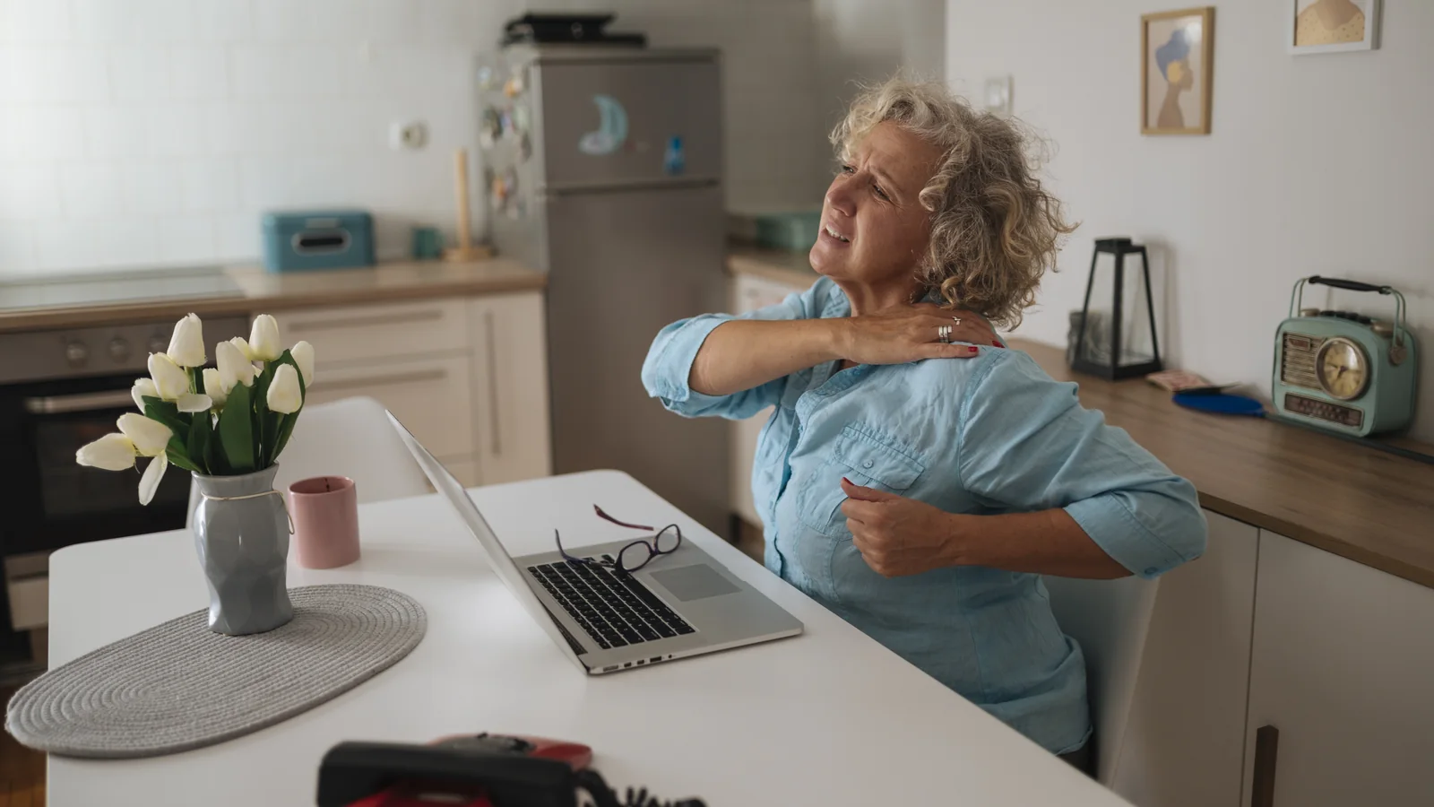 Une femme senior travaille sur un ordinateur portable dans son bureau à domicile